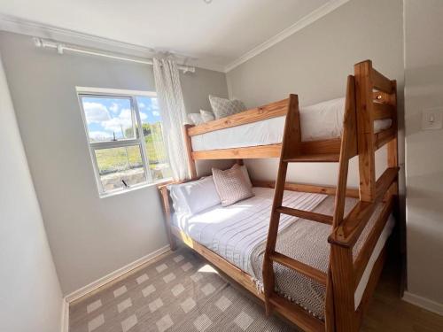 a small room with bunk beds and a window at Bella Casa - Seaview-Beach Club Apartment in Cape Town