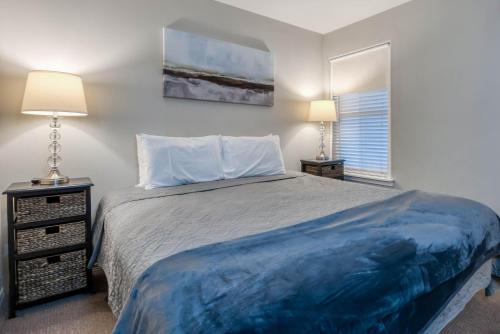 a bedroom with a bed and two lamps and a window at Waters Edge 309 in Lincoln City