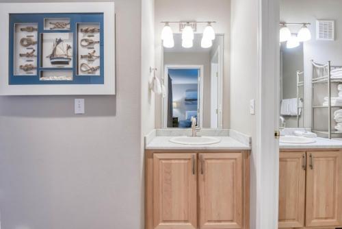 a bathroom with two sinks and a mirror at Waters Edge 309 in Lincoln City