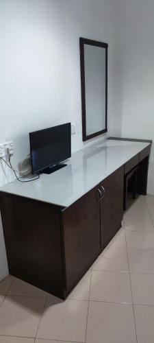 een bureau met een spiegel en een televisie. bij Gold Hill Hotel in Jerantut