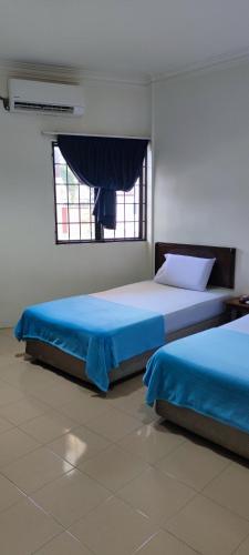 twee bedden in een kamer met een raam bij Gold Hill Hotel in Jerantut