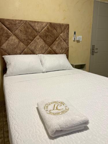 a bed with a white blanket with a tiara on it at HOTEl LA CANDELARIA ROOM HOUSE in Mangue