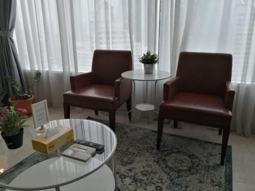 a living room with two chairs and a table at Vortex Suites KLCC by Sayang in Kuala Lumpur