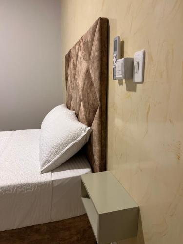 a bed with a pillow and a table in a room at HOTEl LA CANDELARIA ROOM HOUSE in Mangue