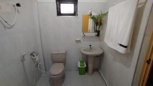 bagno bianco con servizi igienici e lavandino di Sigiri Dilu Villa a Sigiriya