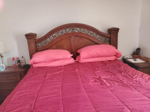 ein Bett mit rosa Bettwäsche und zwei rosa Kissen in der Unterkunft Missouri Holiday Homes LLC 