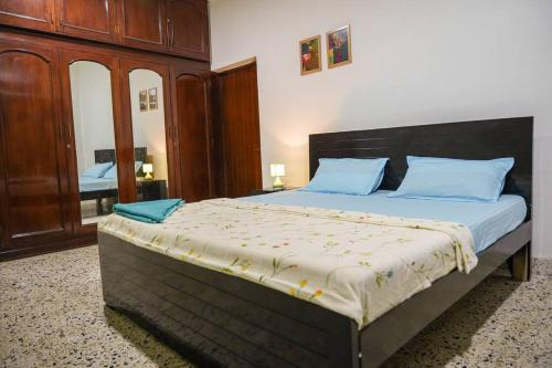 a bedroom with a large bed with blue pillows at Tourist Friendly Home -3BHK AC Near Birla Mandir, Hyderabad in Hyderabad