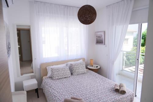um quarto branco com uma cama e uma janela em Narcissos Villa Doria em Protaras