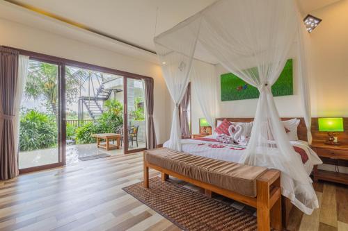 1 dormitorio con 1 cama con dosel en Green Sala Villa en Ubud