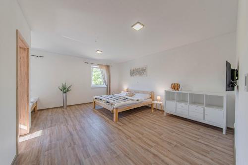 a white room with a bed and a table at Náš Sklep in Brod nad Dyjí