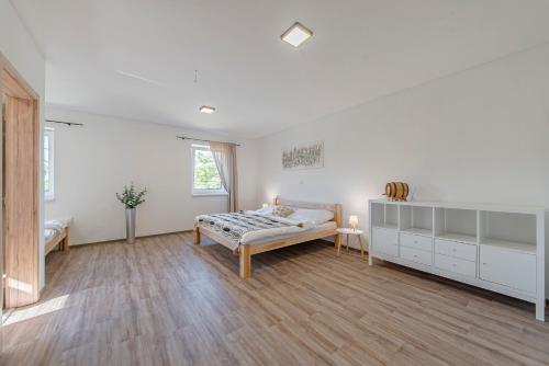 a large white room with a bed and a desk at Náš Sklep in Brod nad Dyjí