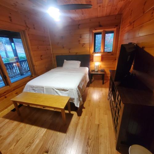 een slaapkamer met een bed en een flatscreen-tv bij Evergreen Retreat in Fleetwood