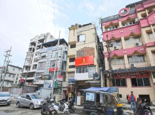 a busy city street with cars and motorcycles and buildings at B&B HOMES Guwahati in Guwahati