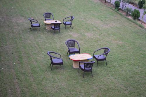 a group of tables and chairs in the grass at Rann Meadows Ranthambhore in Sawāi Mādhopur