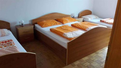 1 Schlafzimmer mit 2 Betten und orangefarbenen Kissen in der Unterkunft Houses and Apt in Smarjeske Toplice Kranjska Krain 26042 in Smarjeske Toplice