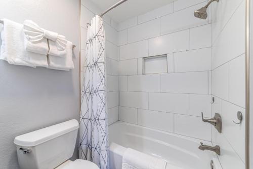 a white bathroom with a shower and a toilet at #521- Luxury Remodeled, Mid-Town Condo in Mammoth Lakes