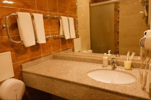 a bathroom with a sink and a toilet and a mirror at Inn OZZ Astana in Astana