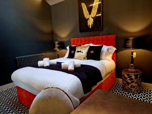 - une chambre avec un grand lit et une tête de lit rouge dans l'établissement The Studio, à Preston