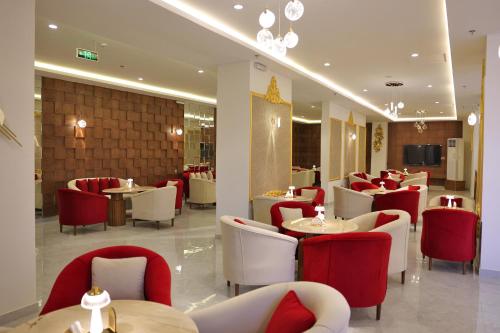 un ristorante con sedie e tavoli rossi e bianchi di فندق الزوين - Alzuwain Hotel a Arar