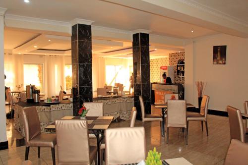 un restaurante con mesas y sillas en una habitación en Fatmols Hotels, en Lusaka