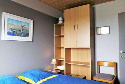 a bedroom with a blue bed and a book shelf at Appartement met zeezicht max 6 p in Ostend