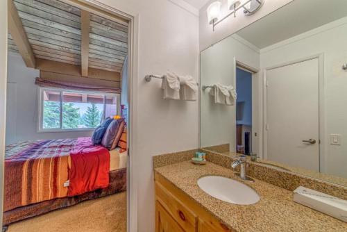 uma casa de banho com um lavatório e uma cama num quarto em #381 - Ski-In Ski-Out Condo with Spa, Game Room, & Pool em Mammoth Lakes
