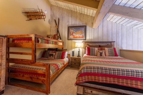 Duas camas num quarto com paredes de madeira em #381 - Ski-In Ski-Out Condo with Spa, Game Room, & Pool em Mammoth Lakes