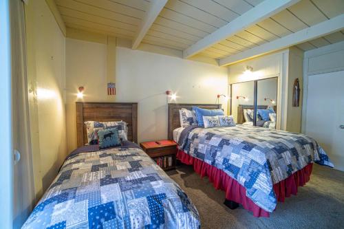 a bedroom with two beds and a mirror at #469 - Pet-Friendly Mountain Condo, Pool & Spa in Mammoth Lakes