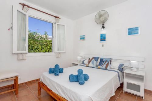 a bedroom with a bed with blue towels on it at Sa Sivina in Cala en Bosc