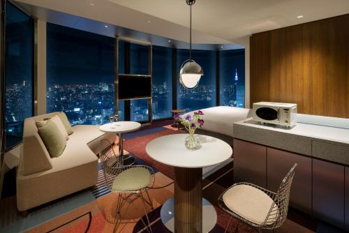 a hotel room with a bed and a couch and a table at HOTEL GROOVE SHINJUKU, A PARKROYAL Hotel in Tokyo