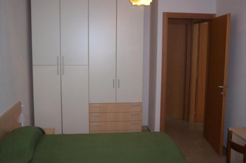 una camera con letto verde e armadi bianchi di Suite Apartments a Cervia