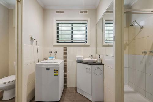 een badkamer met een toilet, een wastafel en een douche bij Grevillea Gardens Unit 4 in Bright