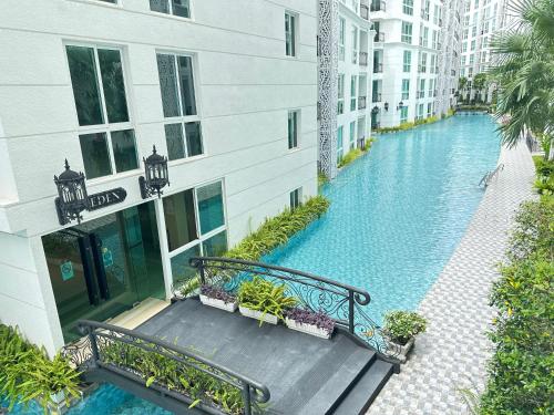 an apartment building with a bench next to a swimming pool at Olympus city garden by jack in Pattaya South