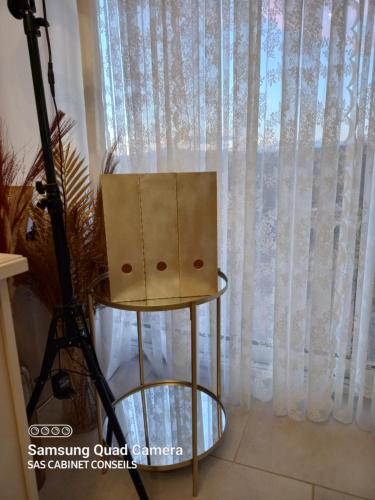 une chaise assise sur un tabouret devant une fenêtre dans l'établissement CABANE COSY, à Revest-du-Bion