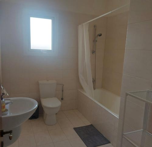 Un baño con inodoro, bañera y lavabo. en The T Villa, en Protaras