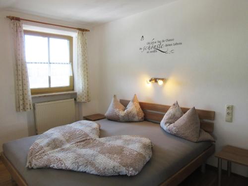 ein Schlafzimmer mit einem Bett mit Kissen darauf in der Unterkunft Geppingerhof in Waging am See