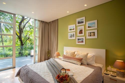 um quarto com uma cama grande e uma janela grande em Elivaas Dahlia Luxe 4BHK Villa with Pvt Pool near Baga em Arpora