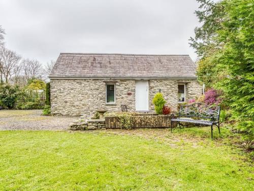 una casa de piedra con un banco en el patio en Secluded Holiday Home in Ceredigion with Garden, en Pennant