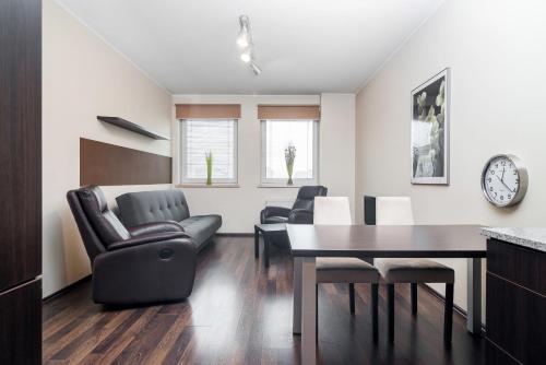 a dining room and living room with a table and chairs at Apartamenty Platinum Inowroclawska Wrocław by Renters in Wrocław