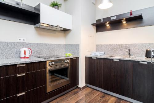 a kitchen with dark wood cabinets and a sink at Apartamenty Platinum Inowroclawska Wrocław by Renters in Wrocław