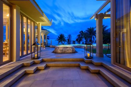 a villa with a view of the ocean at night at Devasom Khao Lak Beach Resort & Villas in Khao Lak