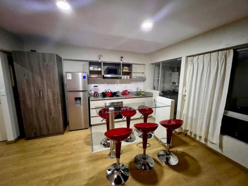 eine Küche mit roten Barhockern und einer Arbeitsplatte in der Unterkunft Apartamento en Jesús María in Lima