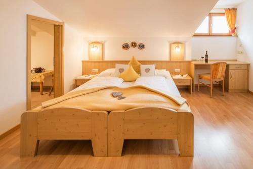 Un dormitorio con una cama grande y un escritorio. en Voppichlhof App Alpenrose, en San Giacomo