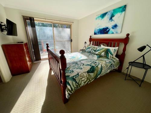a bedroom with a bed and a window at Leafy Retreat in Ulladulla