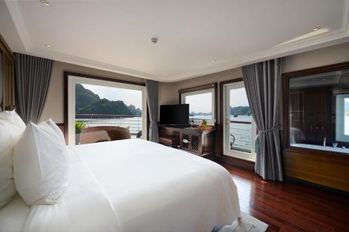 um quarto com uma grande cama branca e janelas grandes em Paradise Grand Cruise - Lan Ha Bay em Ha Long