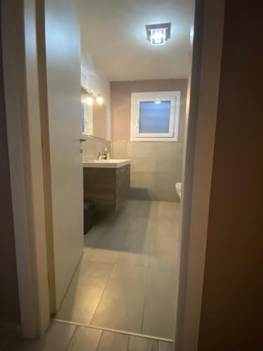 een badkamer met een wastafel, een toilet en een raam bij Appartamento Giotto in Cento