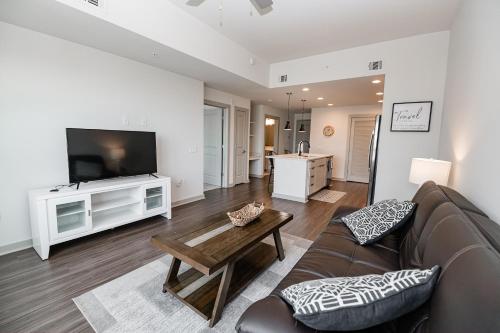 sala de estar con sofá, TV y mesa en Uptown Furnished Apartments near BOA Stadium apts, en Charlotte