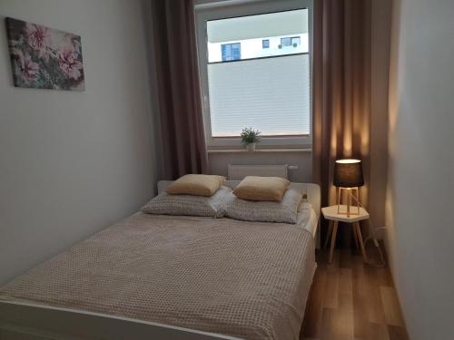 a bedroom with a bed with two pillows on it at Caskada Modern Apartment in Słupsk