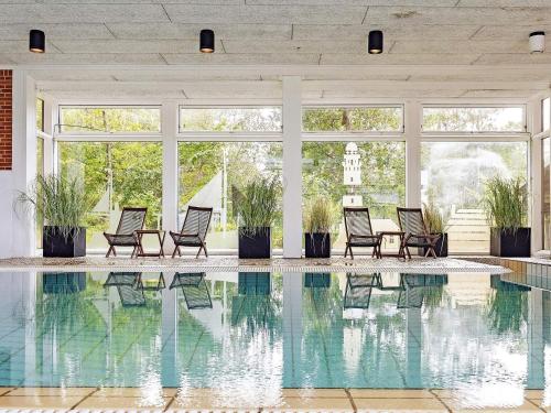 a pool in a house with chairs and windows at 6 person holiday home on a holiday park in Gilleleje