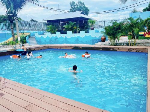 eine Gruppe von Personen, die in einem Schwimmbad schwimmen in der Unterkunft Hồ Cốc Park & Resort in Xã Như Lâm